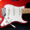a red electric guitar with a white pick up