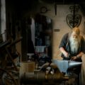 blacksmith holding mallet in garage